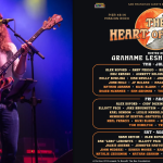 Grahame Lesh plays Phil Lesh’s bass and Grahame Lesh Heart of Town concert lineup art beside him.