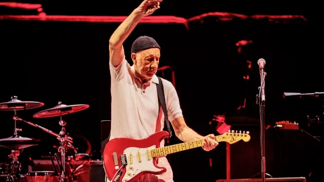 Pete Townshend performs live, celebrating The Who’s Legacy on Tour with his iconic red guitar.