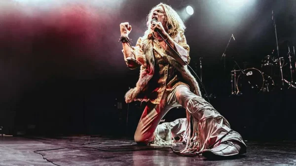 
Kory Clarke of Warrior Soul performing live on stage during Warrior Soul UK Tour, kneeling with microphone and fist raised in passionate rock performance.