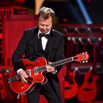 Eric Clapton performing live on stage with his signature guitar and intense expression.