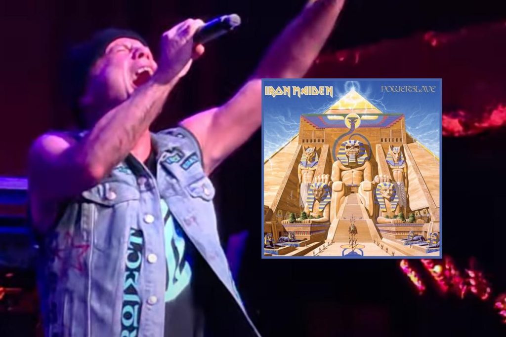 Bruce Dickinson Live Performance with Iron Maiden Powerslave Album Art - Classic Rock Artists Alt Text: Bruce Dickinson performing live on stage with arms raised, microphone in hand, with Iron Maiden's Powerslave album cover featuring Egyptian pyramid artwork displayed alongside.