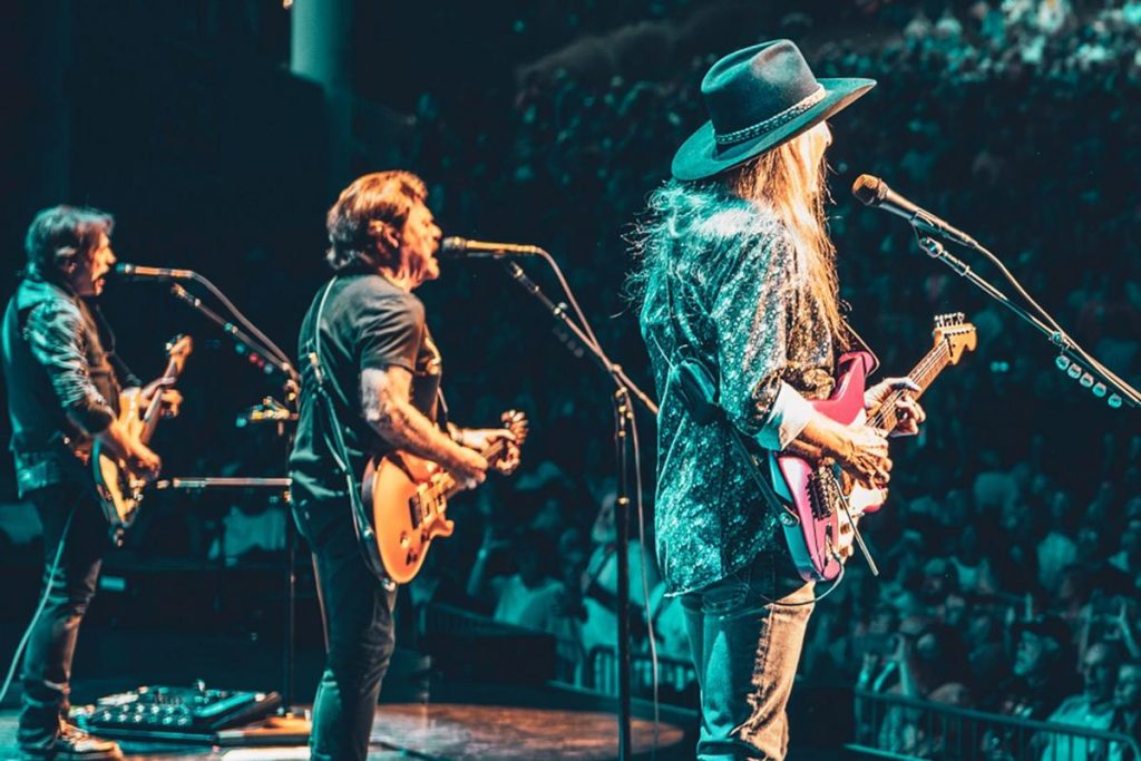 The Doobie Brothers Rock the Stage on Summer 2025 Tour - Classic Rock Artists The Doobie Brothers perform live on stage with bright lights and cheering fans.