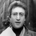 John Lennon smiling with long hair and sunglasses during his New York City years in the 1970s