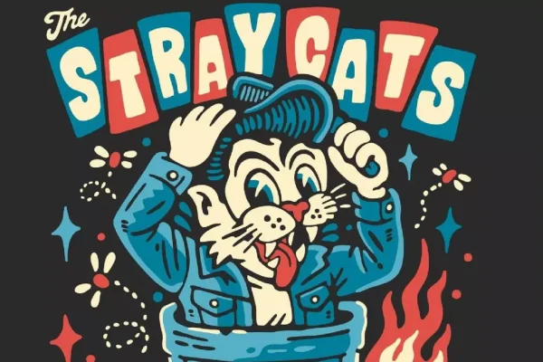 Stray Cats rockabilly trio on stage under neon band logo, Brian Setzer center with guitar, Lee Rocker on upright bass, Slim Jim Phantom on drums.