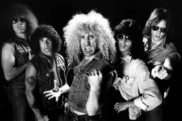Twisted Sister Classic Band Photo - 1980s Heavy Metal Legends - Classic Rock Artists Twisted Sister reunion announcement photo showing the classic heavy metal band in black and white with wild curly hair, denim vests, and sunglasses in their iconic 1980s glam metal style.