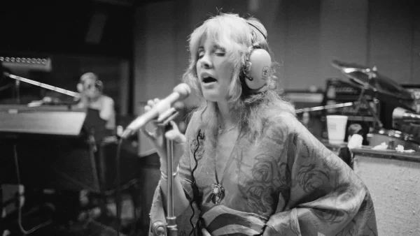 Stevie Nicks Recording Studio Session - Buckingham Nicks Era - Classic Rock Artists Stevie Nicks performing in a recording studio during the Buckingham Nicks era, singing into a microphone while wearing headphones and flowing bohemian clothing in black and white photograph.