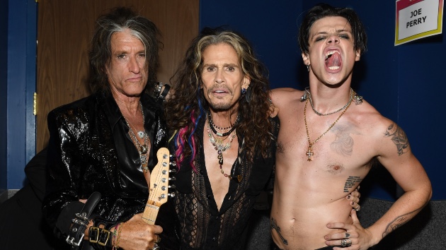 Backstage Moment: Aerosmith and Yungblud After Historic VMAs Collaboration - Classic Rock Artists Aerosmith Yungblud collaboration backstage photo showing Joe Perry with guitar, Steven Tyler, and shirtless Yungblud after their MTV VMAs performance.