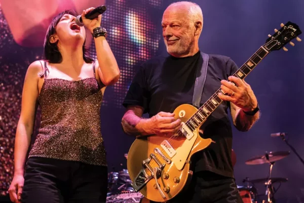 David Gilmour and Romany Gilmour Perform Together During Historic Concert Film - Classic Rock Artists Alt Text: David Gilmour concert film captures the Pink Floyd guitarist performing with his daughter Romany Gilmour on stage during the Luck and Strange tour, with David playing his iconic gold Gibson Les Paul guitar while Romany sings into a microphone under colorful stage lighting.