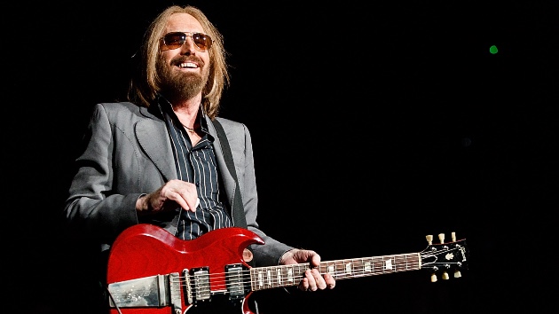 Tom Petty performing live with his signature red guitar, perfect for collectors seeking Tom Petty collectibles
