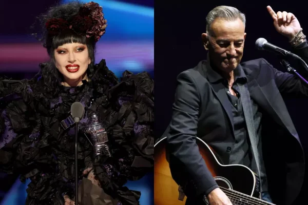 Lady Gaga in elaborate black floral stage outfit with red lipstick holding MTV VMA award next to Bruce Springsteen performing with acoustic guitar in grey suit.