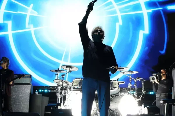 The Who Tea and Theatre Final Performance October 2025 Roger Daltrey of The Who performing Tea and Theatre with arm raised during final American concert October 2025 at Acrisure Arena with blue circular stage lighting and drums visible