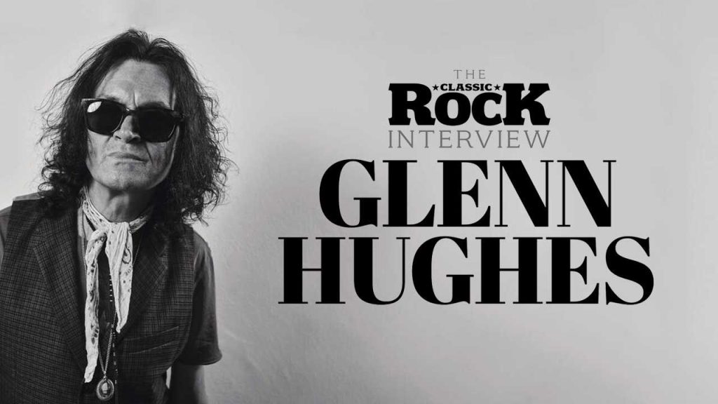 Glenn Hughes wearing sunglasses in black and white photo with text reading The Classic Rock Interview Glenn Hughes.
