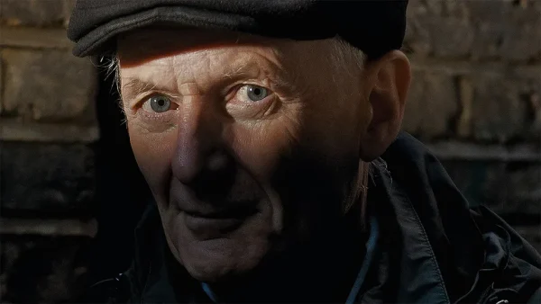 Peter Hammill prog vocalist wearing black beret and jacket looking directly at camera with intense gaze.