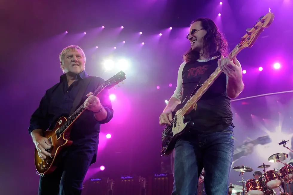 Alex Lifeson and Geddy Lee of Rush performing live on stage with guitars under purple concert lighting ahead of Rush 2026 tour announcement.
