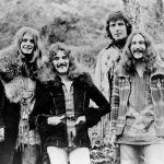 Black Sabbath members Ozzy Osbourne, Tony Iommi, Geezer Butler, and Bill Ward in 1973, standing together in their classic heavy metal style.