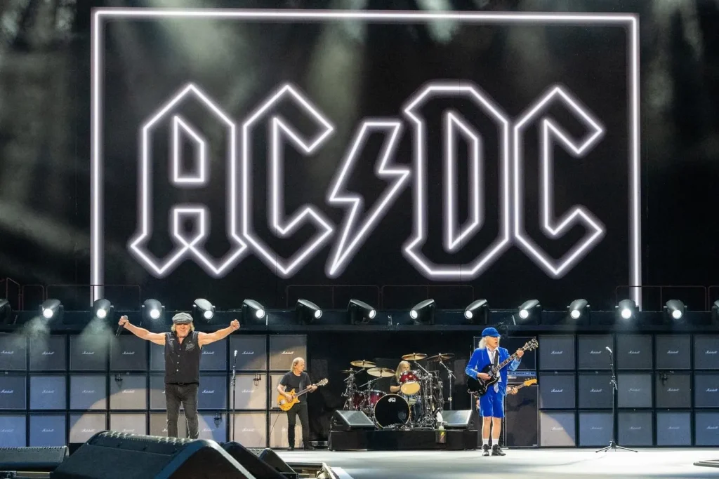 Brian Johnson and Angus Young of AC/DC performing Thunderstruck live on stage at Murrayfield Stadium in Edinburgh with iconic lightning bolt logo backdrop