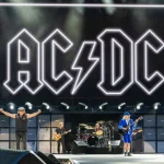 Brian Johnson and Angus Young of AC/DC performing Thunderstruck live on stage at Murrayfield Stadium in Edinburgh with iconic lightning bolt logo backdrop