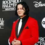 Jack White at White Stripes Rock Hall induction ceremony wearing red suit and white tie in signature band colors.