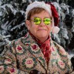 Elton John Step Into Christmas platinum certification celebrates holiday classic with festive Santa hat and signature sunglasses