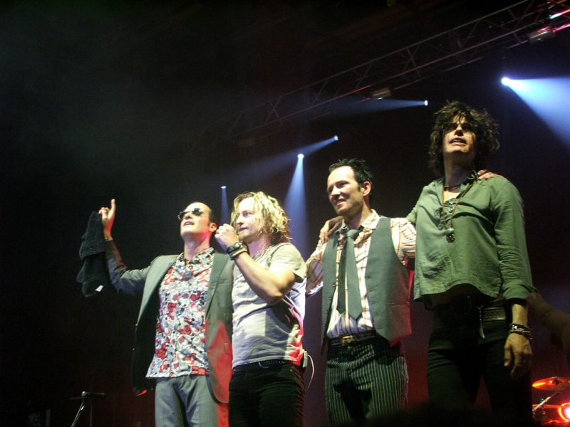 Members of Stone Temple Pilots performing on stage.