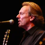 America tour 2026 featuring founding member Dewey Bunnell performing live with guitar at The Happy Trails Tour concert.