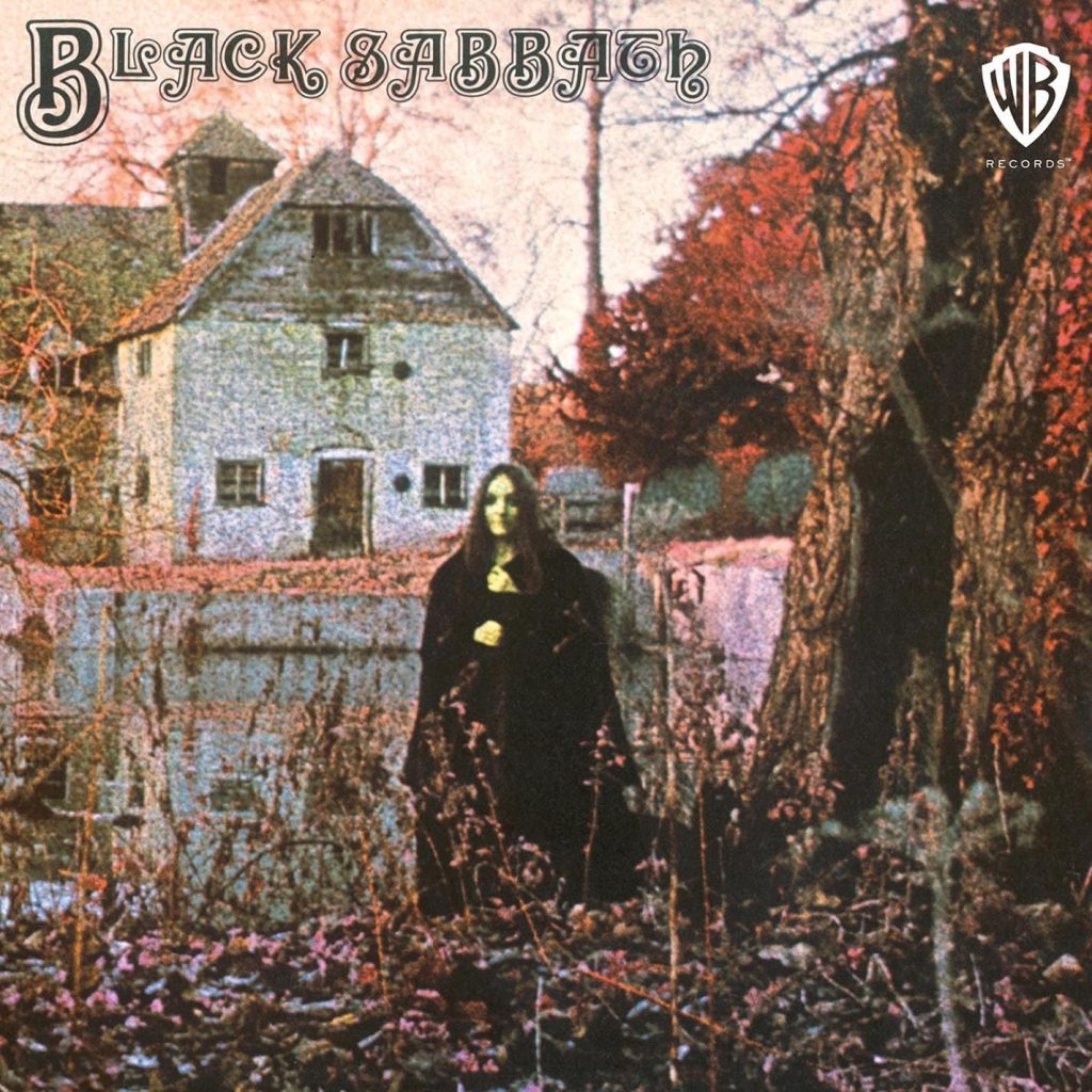 Black Sabbath Black Sabbath 1970 debut album cover featuring mysterious figure in black cloak standing before old water mill Warner Bros Records