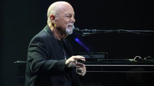 Billy Joel Long Island home owner at piano, property removed from luxury real estate market