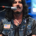 Gilby Clarke performing live with a guitar