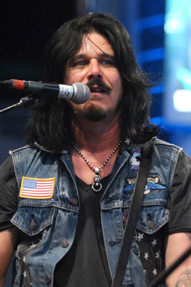 Gilby Clarke performing live with a guitar