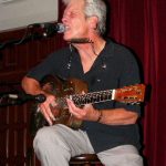 Blues musician John Hammond performing with a guitar.