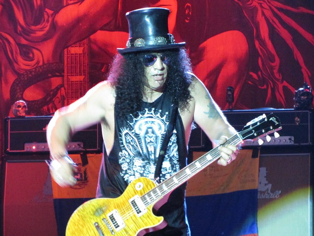Slash performing live on stage with his signature Gibson Les Paul guitar