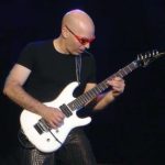Joe Satriani performing live on stage with his signature Ibanez JS guitar