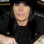 Mick Mars playing guitar live on stage, lead guitarist and co-founder of Mötley Crüe