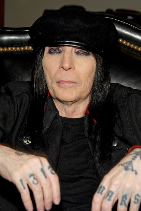 Mick Mars playing guitar live on stage, lead guitarist and co-founder of Mötley Crüe