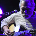 Jorma Kaukonen playing acoustic guitar on stage in 2009